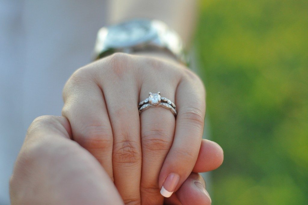 Woman with engagement ring in hand