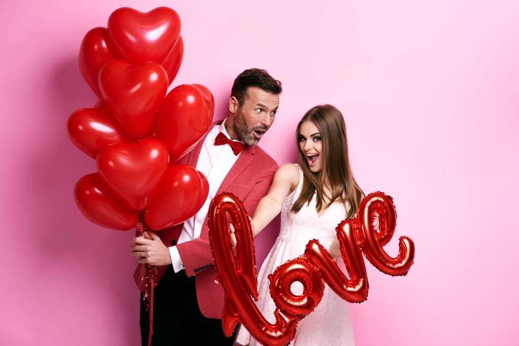 Happy couple with hearts and love balloons