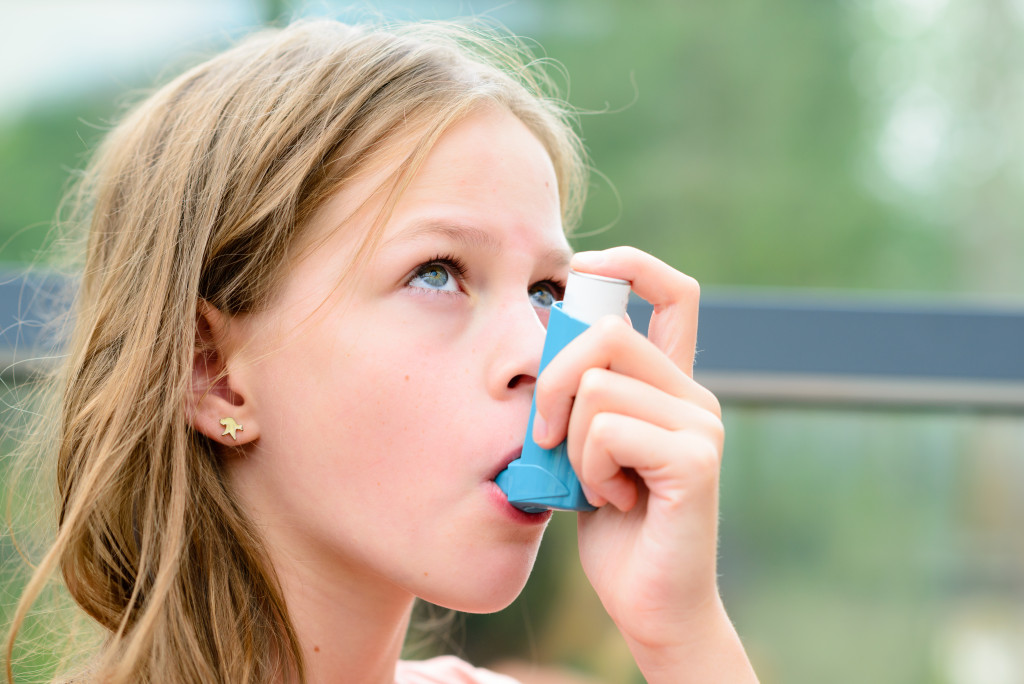 A young girl using an inhaler